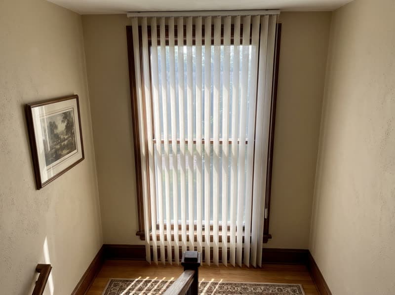 Dream curtain vertical sheer on a stairwell landing window in a traditional two-storey house in Buford