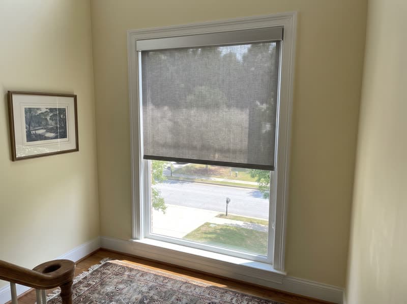 Roller shade on a stairwell landing window in a traditional two-storey house in Buford