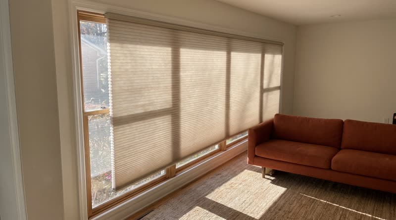 Honeycomb cellular shade on a living room window in a 1970s split-level in Marietta