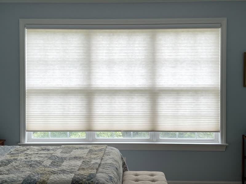 Honeycomb cellular shade on a guest bedroom window in a 1990s brick colonial in Woodstock